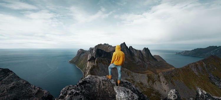 global-debt-mountain-person-looking-over-mountain-peaks