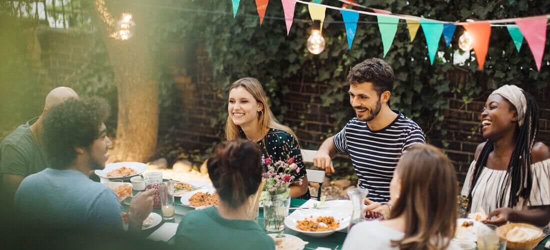 a group of people eating and drinking together outdoors