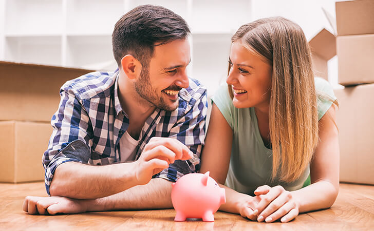 Couple saving in a piggy bank.